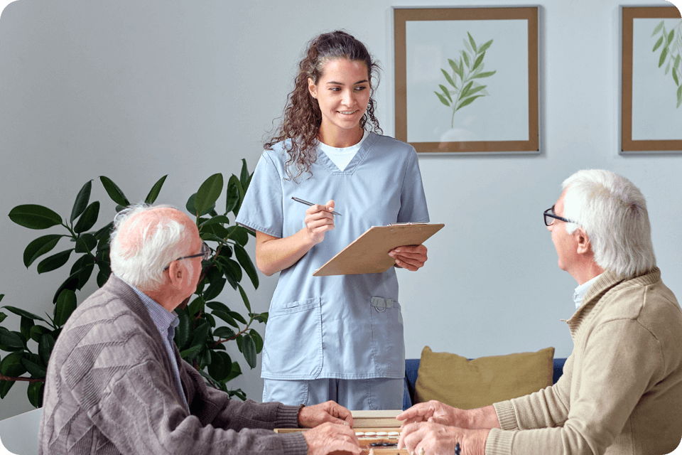 senior living care worker talking to two senior citizens